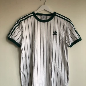 Adidas shortsleeve grön - Vit t-shirt från Adidas med gröna ränder. Sparsamt använd.