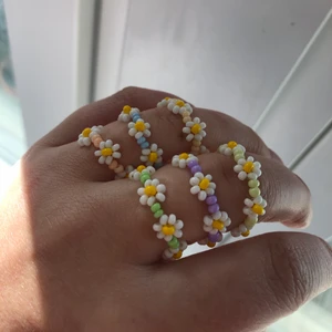 Ringar - Säljer pärlade ringar med blommotiv i olika färger. Finns i färger ljuslila, mörklila, ljusblå, blå, ljusgrön, grön, turkose, gul, mörkröd, pastell orange, genomskinlig rosa, pastell brun. Går att få i alla storlekar. Köparen står för frakten!