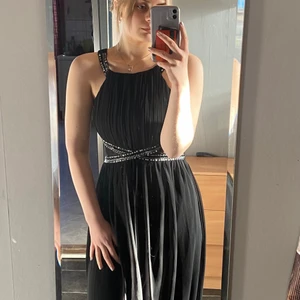 Balklänning - Svart vacker klänning med glitter detaljer. Passar perfekt vid tillfällen som bal etc. Klänningen är i mycket gott skick då den använts endast 1 gång. Säljer på grund av för stor och har inte längre användning. Den är i storlek 42, men är ganska liten/normal i storleken.