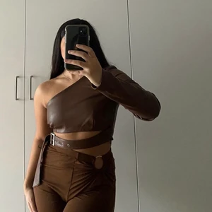 PU topp från NAKD - Jättefin PU top med reglerbart band och dragkedja. Endast testad några gånger. Nypris 449kr