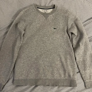 Tröja Lacoste - Verkligen perfekt skick. Säljer då jag växt ur den. Hur fin som helst.