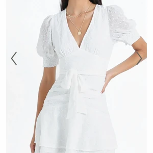 Vit klänning - Intressekoll, kollar intresset på denna fina vita klänningen från showpo. Köpt i storlek 32 men passar även en 34. Bandet är justerbart och går att knyta fram eller bak, aldrig använd med prislappen kvar. Kan skicka mer bilder vid intresse!!