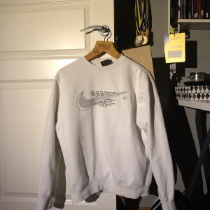 Vit Nike SWOOSH sweatshirt strl S/M - Plagget är i bra skick, använd runt 10/20 gånger men inga skador utöver att den är lite sliten på insidan! Är storlek S men fungerar även vissa medium :) Köpt på ASOS för 600kr. Säljer på grund av att jag vuxit ur.