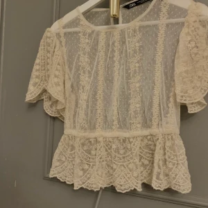 Spets topp från Zara. Stl xs - En vit spets jättesöt topp. Helt oanvänd. Köpte för typ ett halvår sen. Det är Xs men passar jättebra för S också. Frakt får köparen stå för💘💘💘
