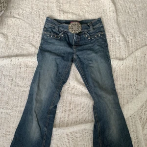 Y2K inspirerade lågmidjade byxor  - Jätte coola Y2K inspirerade byxor med inbyggt skärp. Lågmidjade med coola metalldetaljer både fram och på fickorna bak! Super snygga men tyvärr satt dom inte på bra på mig. Storlek 158 i barnstorlek men passade mig som har XS!