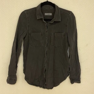 Rockig skjorta i ”washed grey” - Snygg rockig skjorta i ”urtvättad grå look” ascool skjorta!  Köparen står för frakten. Jag ansvarar inte för postens hantering. Jag visar bild på när jag skickar paketet. Vid fler intressen av objekt kan bud över begärt ingångspris läggas.