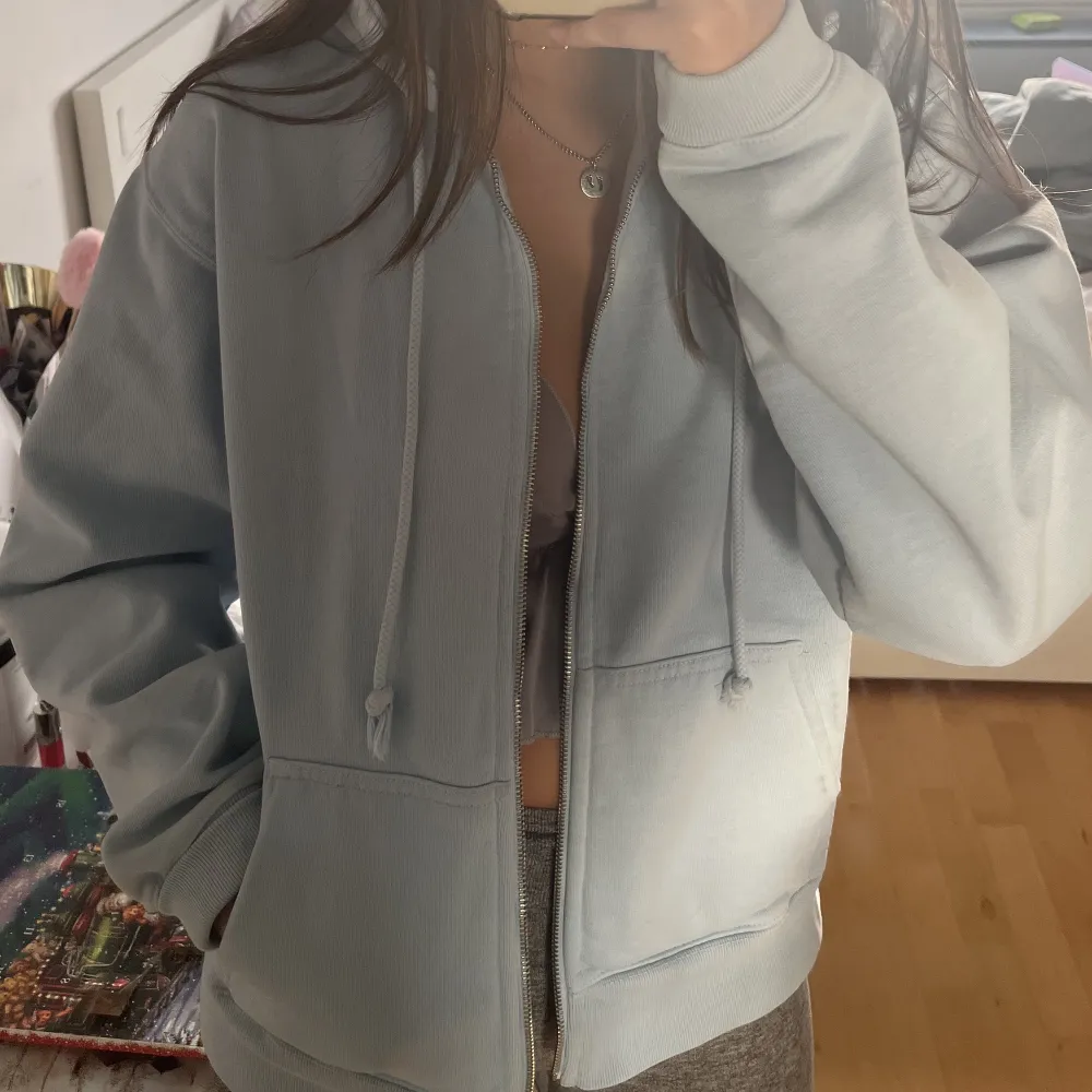 Superfin ljusblå ziphoodie från Brandy Melville i oversized fit. Har en liten blekfläck (bild 3) 🤍 Färgen är svår att få på bild men är som en kombination av första och andra bilden🫶. Tröjor & Koftor.