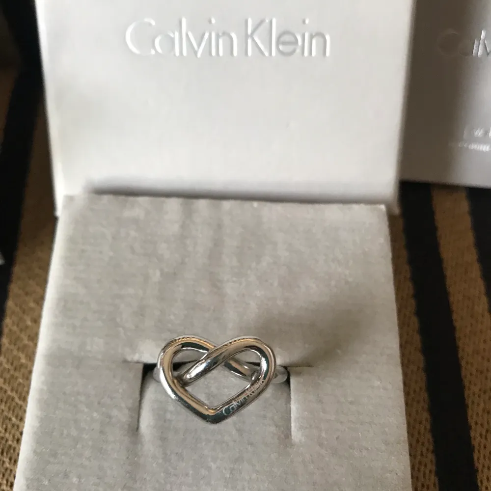 Superfin metallic charmig rostfritt stål knuten hjärtring från Calvin Klein.. Accessoarer.