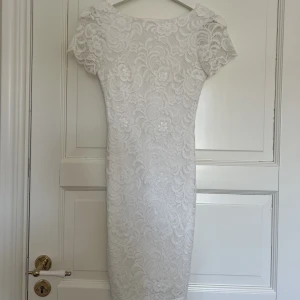 Vit klänning - Vit spetsklänning i storlek XxS, köpt på bubblerooms hemsida. Klänningen är endast använd en gång, under min student 2021 alltså är klänningen i väldigt fint skick. Sista bilden är lånad från bubblerooms hemsida 