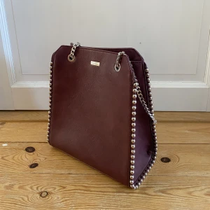 Don Donna väska - Väska från Don Donna. Köpt på rizzo secondhand avdelning. Använd av mig ungefär 2 gånger. Enda defekten är att tyget börjat spricka lite på ena axelskyddet, syns bara om man kollar noga. Skriv för fler bilder eller vid frågor!