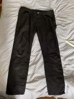 Svarta Acne-jeans i modellen ”River - Stay Black”. Slim fit / tapered legs, nästan helt oanvända. 32/34