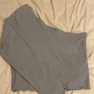 Crop-top med en ärm  - En baby-blå topp med en ärm. Skönt material och stretchig. (den är ljusare än på den första bilden)  