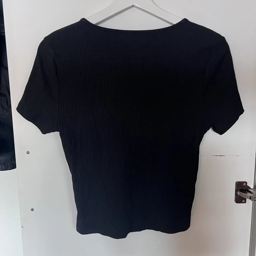 En svart ribbad T-shirt från Bikbok i storlek L. Använd ett fåtal gånger, fint skick.. T-shirts.
