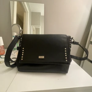 Feel axelremsväska - Jätte söt väska med nitar från FEEL med justerbart band! Väldigt mycket utrymme och bra fack för att kunna förvara saker på💞 