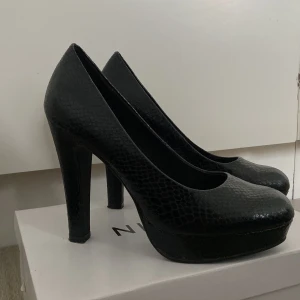 Svarta ormskinn klackar  - Klackskor, svart ”ormskinn” Nyskick, använda en gång  Storlek 37/38