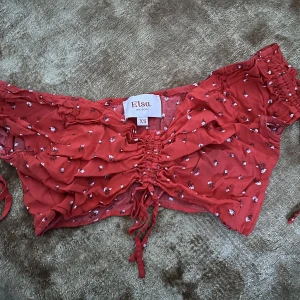 Croppad topp - Croppad topp med dragsko frampå samt på ärmarna. Från kollektion med Elsa hos på bikbok.