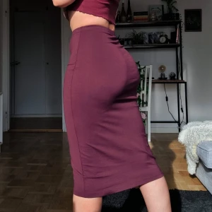 Vinröd pennkjol - Denna är aldrig använd, så i helt nytt skick! Midi längd. Jag på bilden är 162 cm lång och den slutar under knäna på mig. Strl XS men har mycket stretch så passar definitivt en S (36-38) som jag på bilden är. 