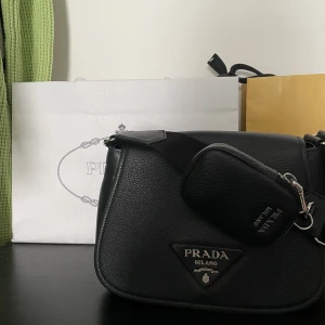 Prada väska  - Äkta prada väska i läder säljes köpt på Farfetch, väl använd men i mycket bra skick. Äkthetsbevis finns men tyvärr inget kvitto. Storlek 24x17x9.5cm, ordinariepris 21000kr