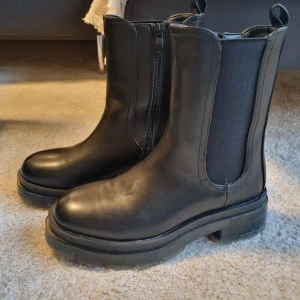 Svarta boots srl 36 - Säljer dessa svarta boots i stl 36. Aldrig använda. Fodrade. Dragkedja.  Köparen står för frakten.