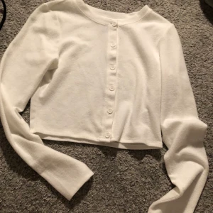 Vit kofta - Vit kofta från hm, köpte förra året. Knappt använd. Har tyvärr ingen bild på. Passar xs/s. Frakt tillkommer på 35kr.