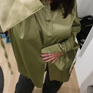 NA-KD stjorta  - Säljer den snyggaste NAKD stjortan! Jag har använt den ca 5-6 gånger så den är i princip ny. Man kan använda den som en oversized stjorta men också som klänning med ett par höga eller låga boots då den är i storlek L! Svinsnyggt!😍☀️❣️