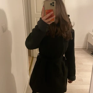 Kappa - Svart kappa med ett band man knyter runt midjan huva finns på kappan.  den är från New yorker Storlek 38 