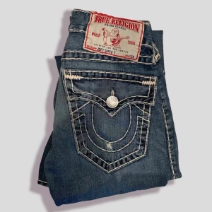 True Religion Jeans👻 - Asgrymma true religon brallor i modell ”joey super t”. Jeansen har en skön flare/bootcut och är i nöstan perfekt condition förrutom en liten rip på bakfickan 💜🖤 #BenimDenim innerben 81cm ytterben 108cm midja storlek 33  