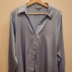 Blå blus - Ljus blå blus från H&M andvänd på en fotografering 