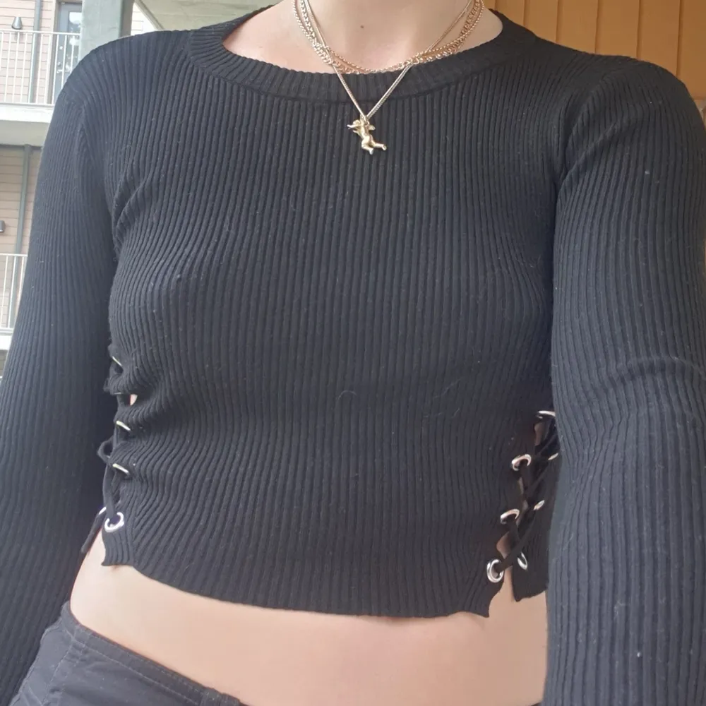 Black knit lace-up underboob detail sweater, very soft. Stickat.