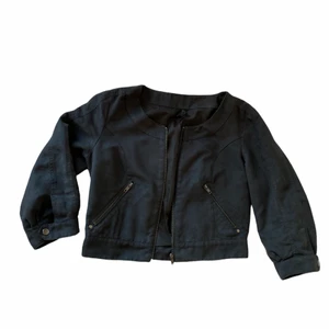 Sommar jacka  - En somrig svart jacka med armarna till armbågarna med snygga detaljer och dragkedja. 