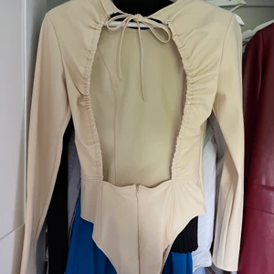 Body med öppen rygg - Body från zara med öppen rygg i en fin beige färg. Den är helt oanvänd. Storlek S💘 Skriv för fler bilder eller om du har några frågor. Köparen står för frakten 💕