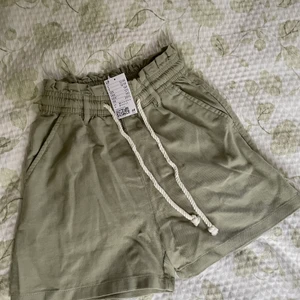 Shorts kaki  - Shorts från hm i grön kakifärg, aldrig använda med prislapp kvar. Storlek 32, skulle säga att de passar en 34 lika bra