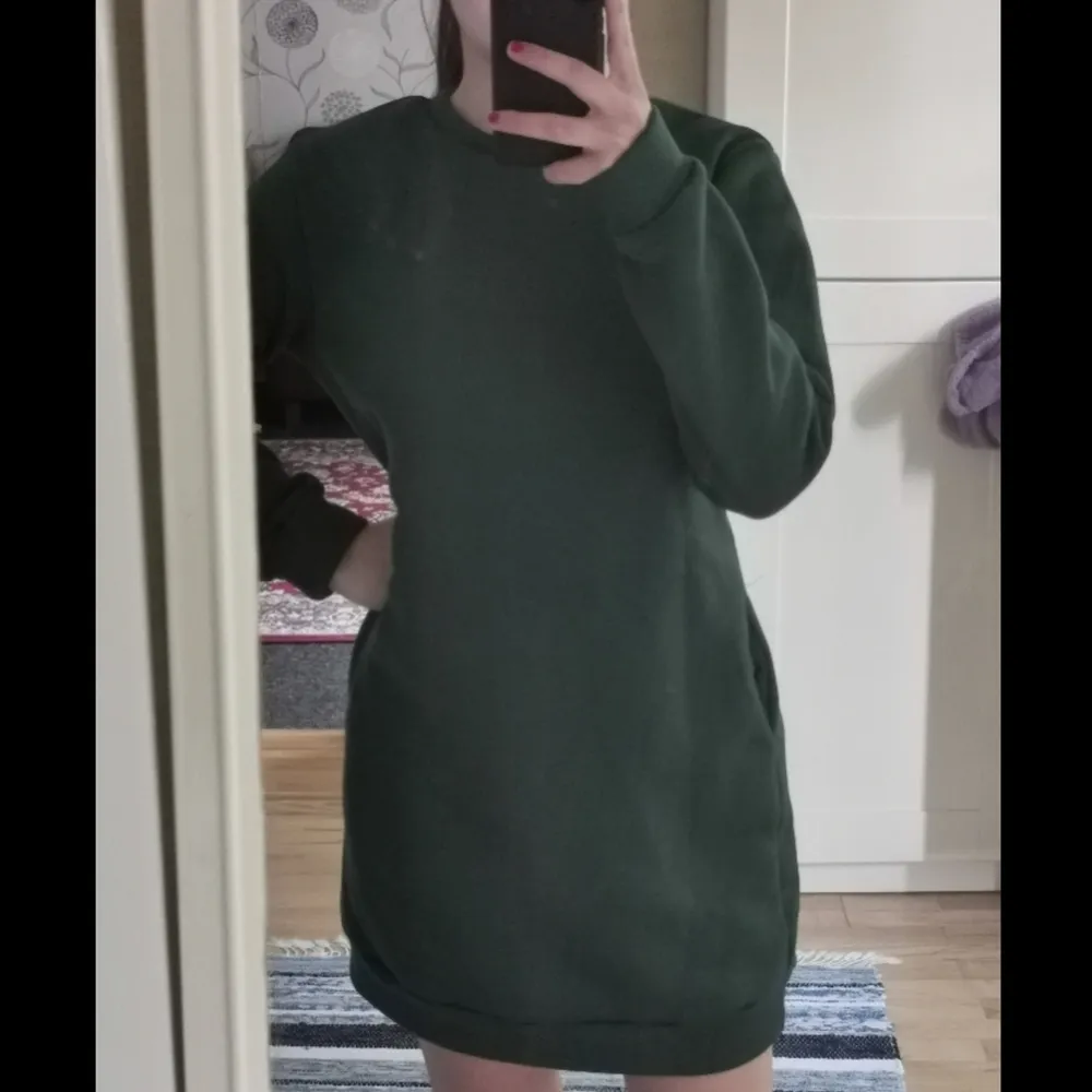 En mörk grön lång tröja som kan också användas som klänning. Det här ett tjockt och varmt tyg som är väldigt skönt. Jag är 1.60 och därför kan det ses längre på mig. . Hoodies.