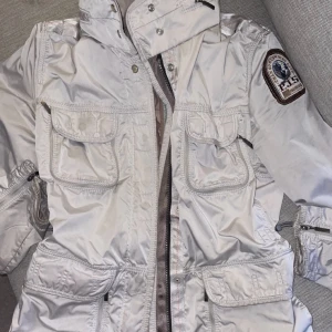 Parajumper windbreaker  - Parajumper windbreaker storlek xs men passar även S. Beige, slutsåld överallt.  Man kan spänna in hur man vill i midjan och det finns även en ”inbyggd” luva man kan ta ut om man vill. 