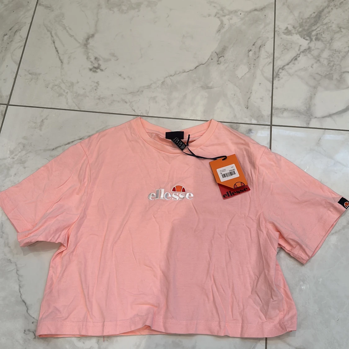 En ljus rosa ellesse t-shirt
