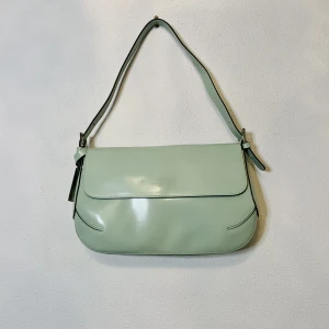 Turkos axelväska - Snygg turkos axelväska som används endast några få gånger. Snygg, trendig och passar till många plagg. Den är gjord av äkta läder och är rymlig jämfört med många andra axelväskor💗 