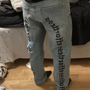 Jeans med tryck - Ljusblå jeans med text på. Knappt använda och har då ett bra skick!