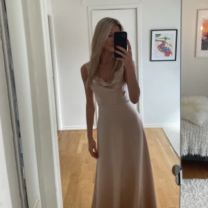 Balklänning - säljer min fina balklänning. Den är champagnefärgad med en öppen rygg och veckad fram i bröstet. Den är från Ivory Field men namn ”luxe satin Jenny v-back dress” i storlek 36/4. Ordinarie pris är 3299kr. Har en liten skråma fram som syns i vissa ljus