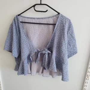 Knutblus  - Nästan oanvänd blus, kort med volanger. Är i storlek xl men passar mer L/M