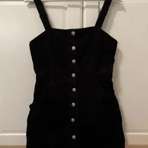 En svart manchesterklänning från H&M. Den är i minilängd i a-linjemodell och har fickor framtill. Använd ett fåtal gånger men i bra skick. Pris kan diskuteras!