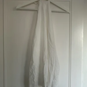 Vit klänning med öppen rygg  - Säljer denna vita klänning med öppen rygg, en perfekt klänning inför sommar, student eller skolavslutning. Klänningen är endast använd fåtal gånger och är i bra skick. 