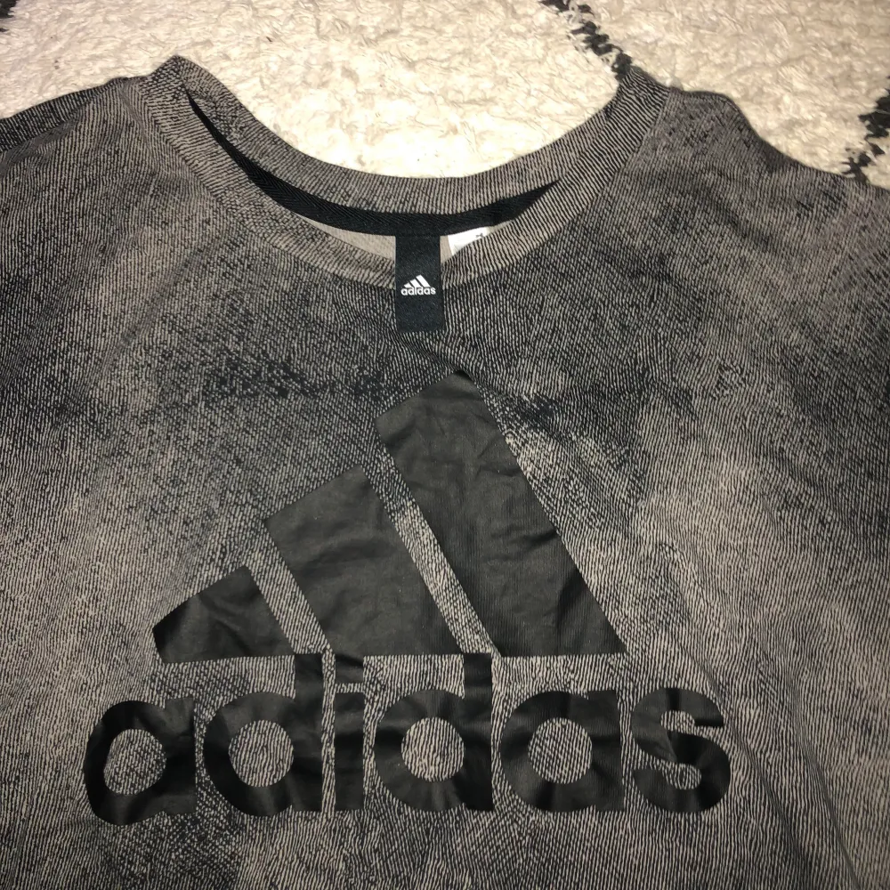 Adidas t-shirt, grå/svart med ett svart adidasmärke. Oanvänd, bra skick!. T-shirts.