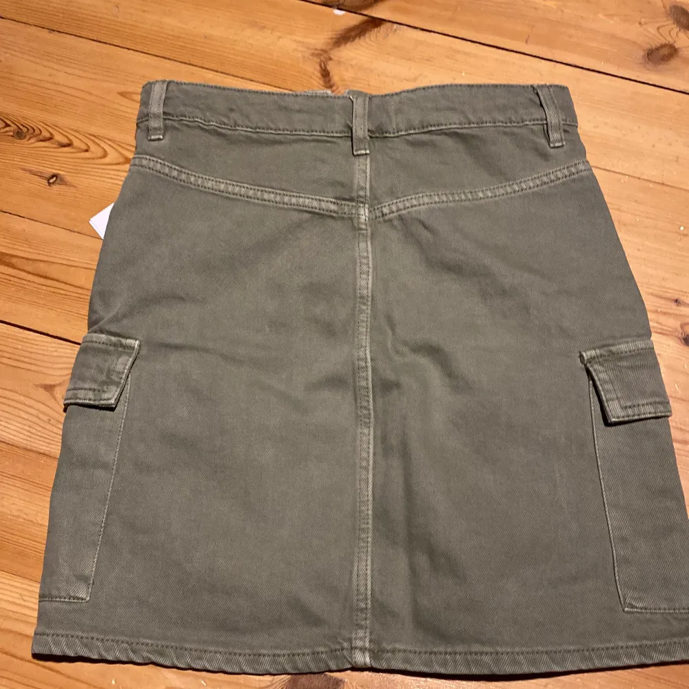 Grön cargo-liknande Gina tricot jeanskjol. Storlek 34. Prislapp kvar så aldrig använd förut, originalpris 300. Kjolar.