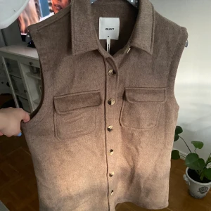 Object väst  - Brun väst från Object med ull liknande material. Aldrig använd, men ingen prislapp. Ganska lång, går över rumpan. 