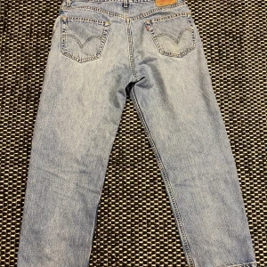 Levis 550 - Bra skick, lite sliten längst nere på benen. Vida ben som sitter lite baggy men ändå clean. 