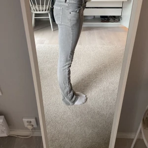 Gråa Levis jeans  - Gråa jeans med klippt slits. Köpta för länge sedan och tyvärr blivit för små.