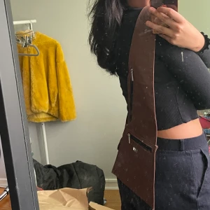 Stilren platt brun slingbag - Söt sling bag köpt på Humana. Frakt ej inkl i priset<3 oanvänd av miiiig. 