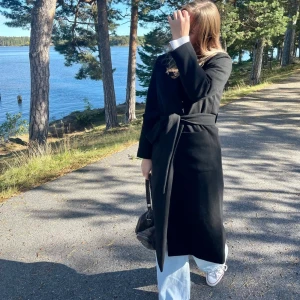 Svart ullskappa Ellos  - En svart kappa från ellos inköpt hösten 2021. Lång rak modell med stora fickor. Är helt slutsåld på hemsidan varav den bruna på sista bilden. Väldigt sparsamt använd. Nypris 899kr 