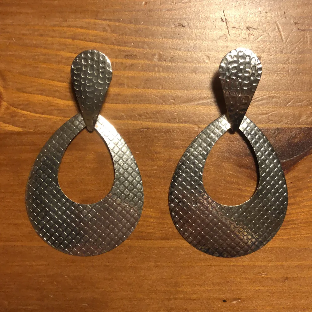 Ett par silvriga örhängen från H&M Ca 6 cm långa. Accessoarer.