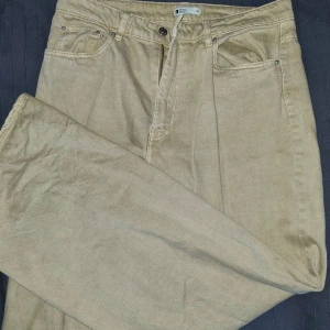 Gina Tricot Vida Beige Jeans - Vida jeans i beige färg, strl 42 men stor i storleken. Tjockt material utan eller med minimal stretch. Frakt inräknat i priset.